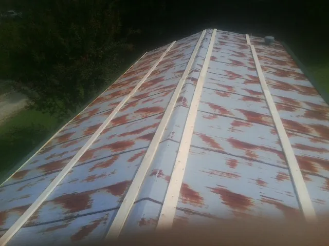 Rusted metal roof panels with new wood purlins before replacement — Storm Damage Roof Repair in Creekside by Roofing Brothers