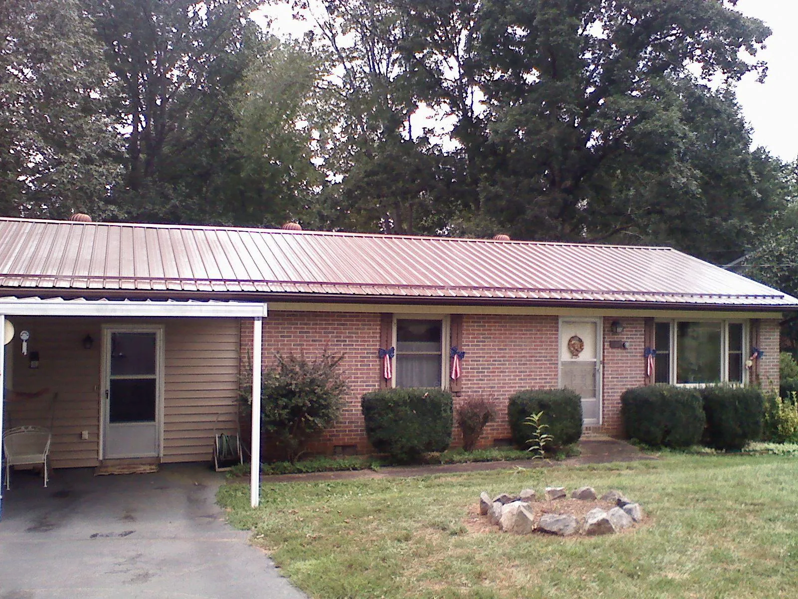 Bronze metal roof and carport on a brick ranch home — Roof Repair work by our crew in Creekside
